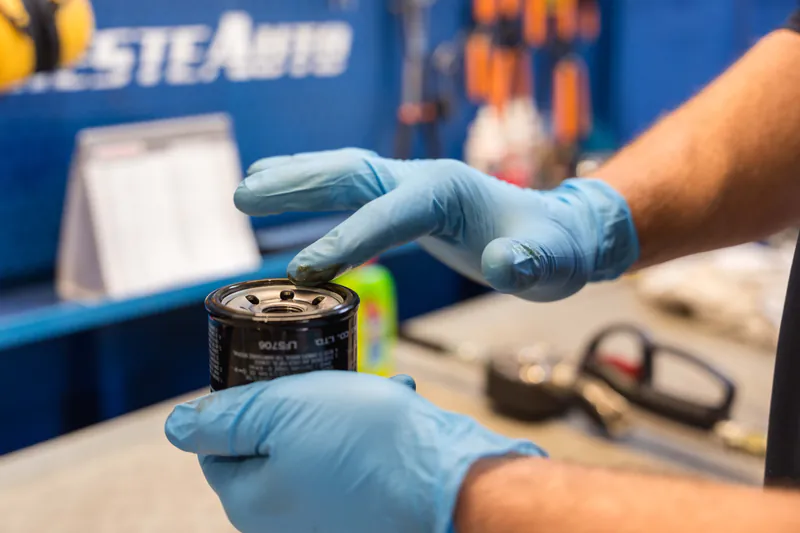 Filtro dell'olio originale in mano al tecnico dell'officina Trieste Auto, concessionaria Suzuki a Muggia (Trieste), pronto per il cambio olio